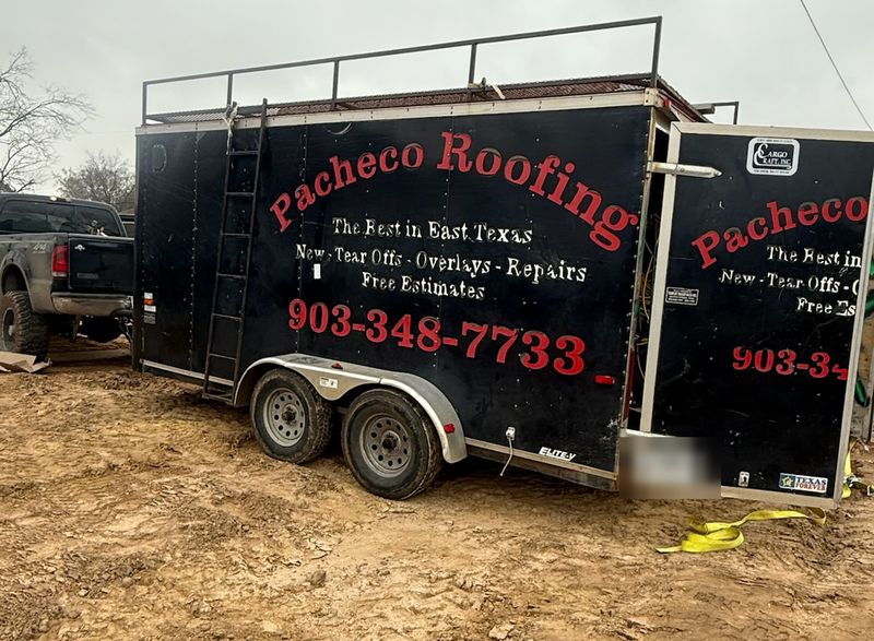 Black Pacheco Roofing trailer with red lettering and the phone number 903-348-7733